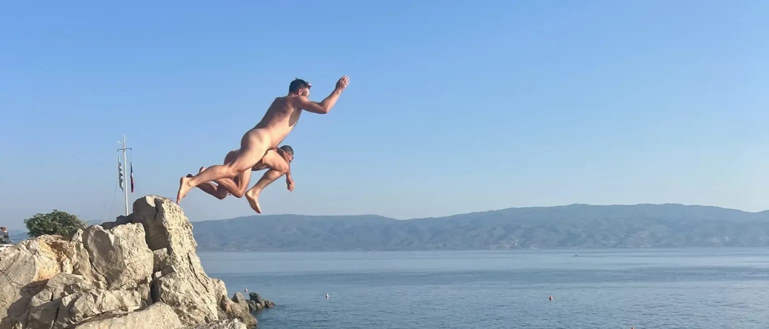 Jumping off a rocky point into the sea in Greece