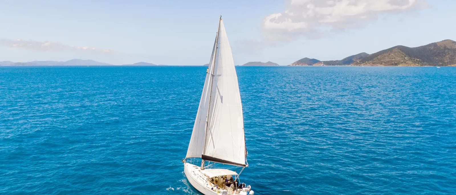 A sailboat under full sail on open Caribbean water