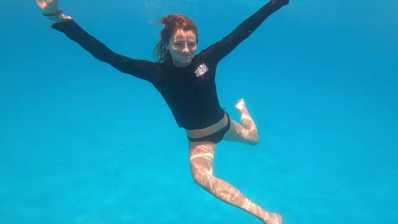 A Sailing Virgins student swimming underwater in clear blue water