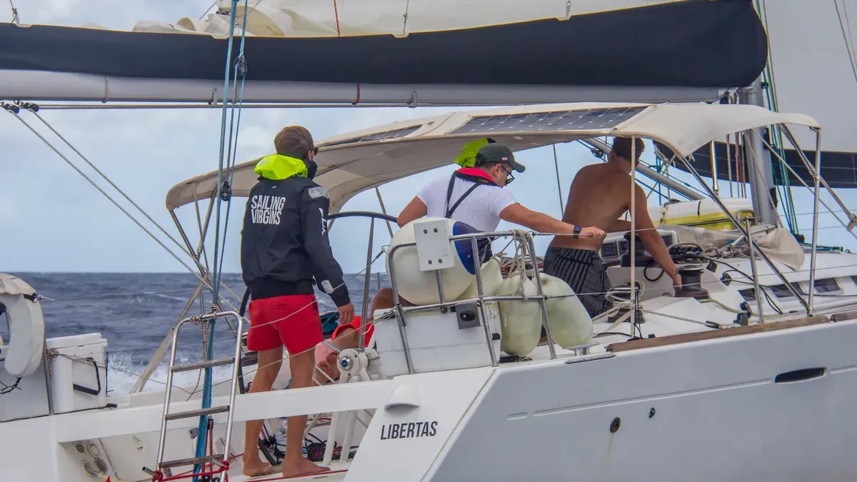 Students working together in the cockpit while sailing