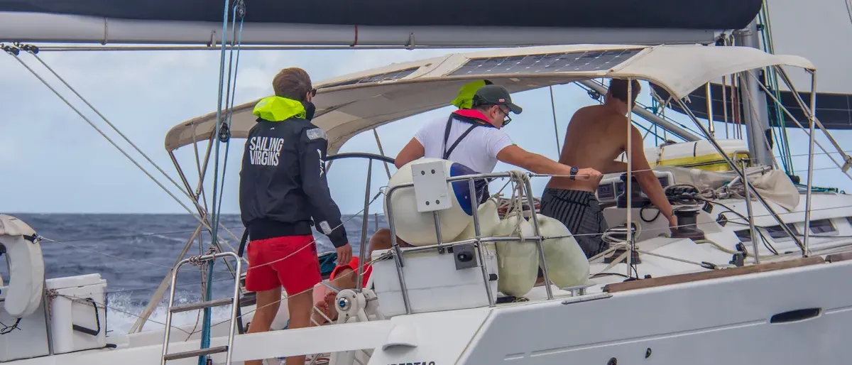Students working together in the cockpit while sailing